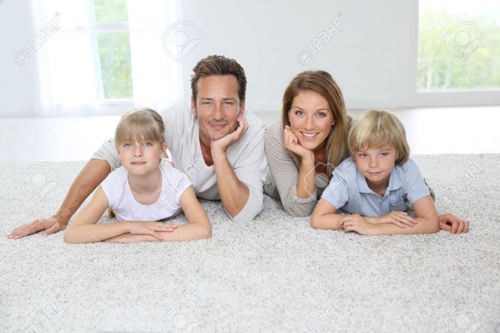 29377558-Happy-family-of-four-laying-on-carpet-at-home-Stock-Photo